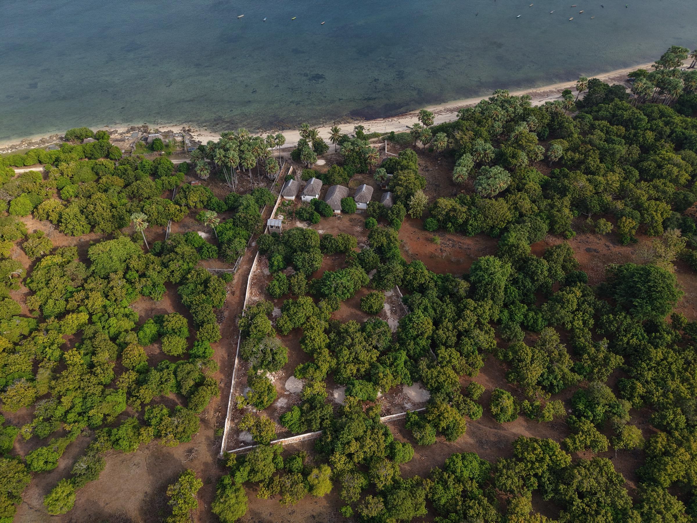 Aerial view of the beach with fishing boats moored beyond the reef