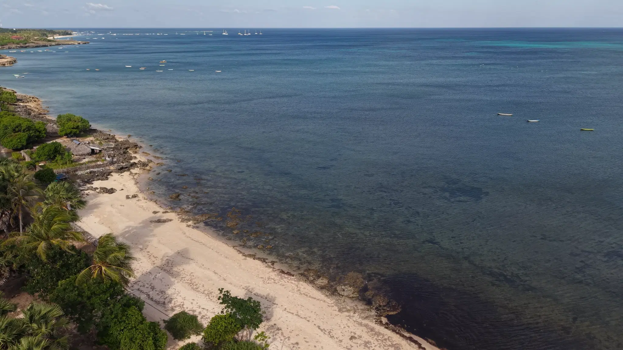 Aerial view north along the beach at Sedeoen, Rote Island, the reef flat and the boats moored off Nemberala beyond
